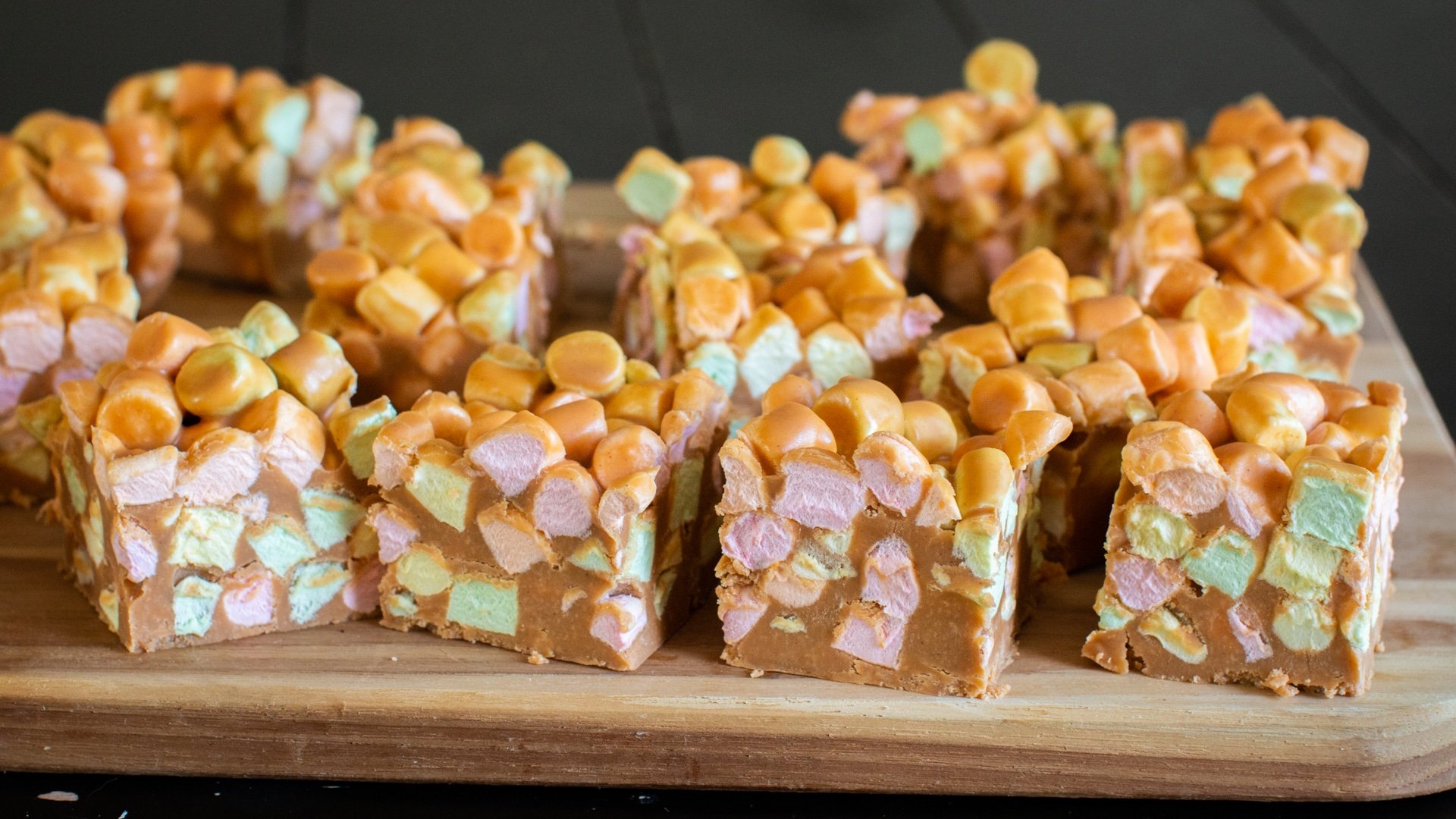 marshmallow squares on a wooden cutting board.