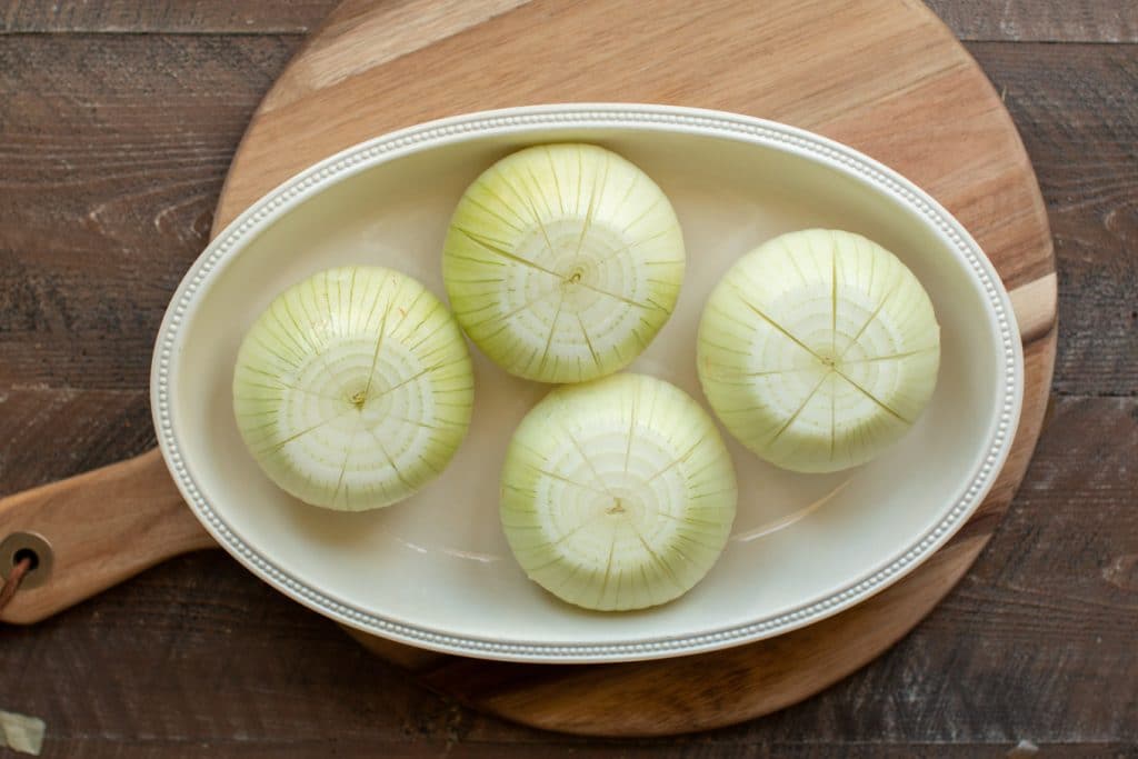4 raw onions in a baking dish