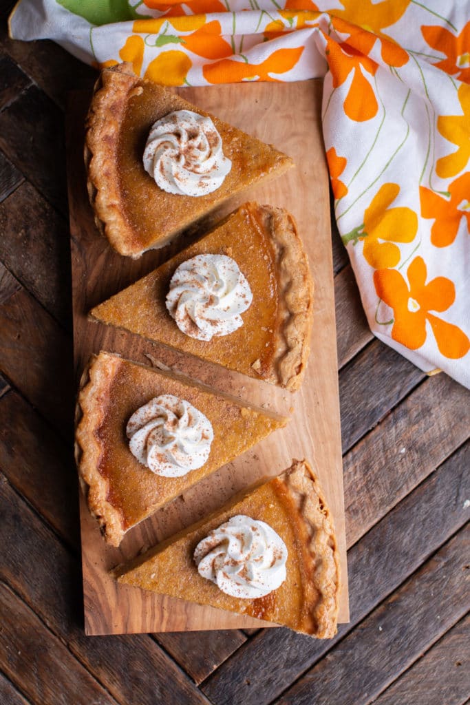 pumpkin pie slices with whipped cream on top.