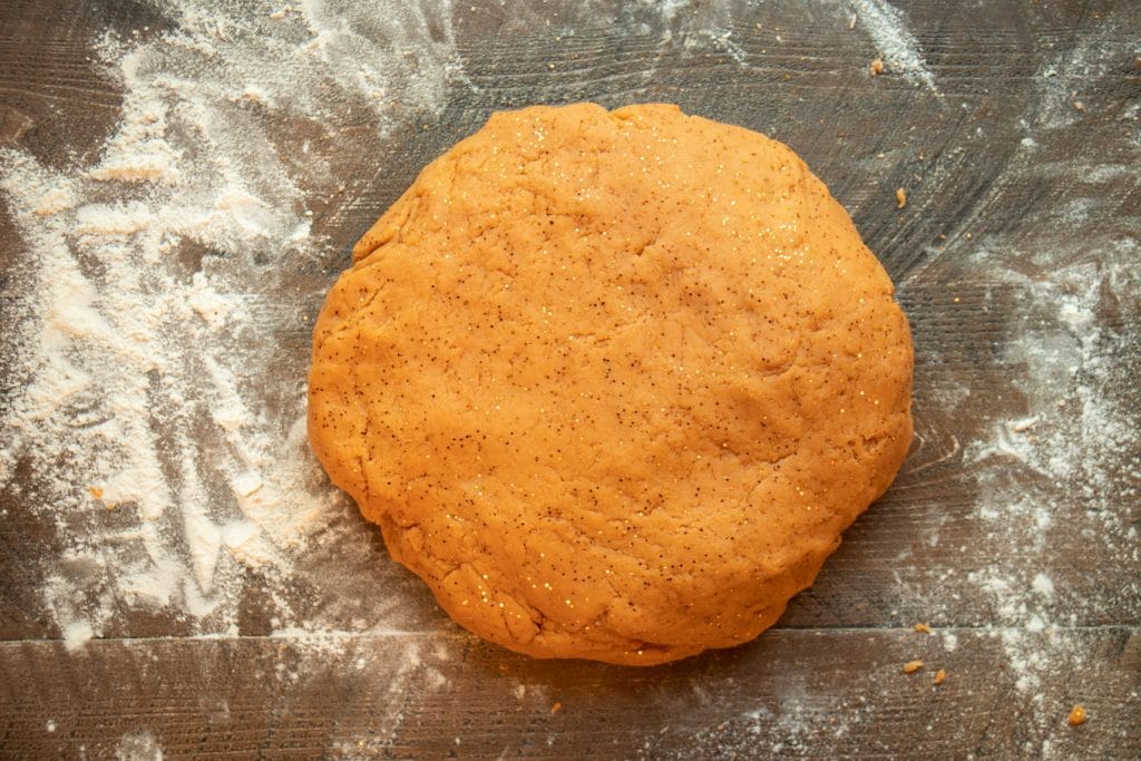 pumpkin dough on wooden table in a flat round.