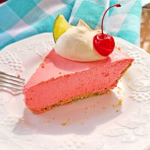 slice of cherry lime pie on plate with whipped cream and cherry
