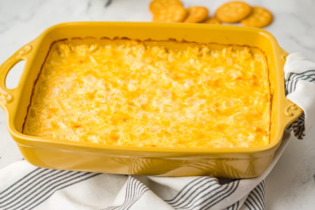 vidalia onion dip in baking dish with ritz crakers on the side