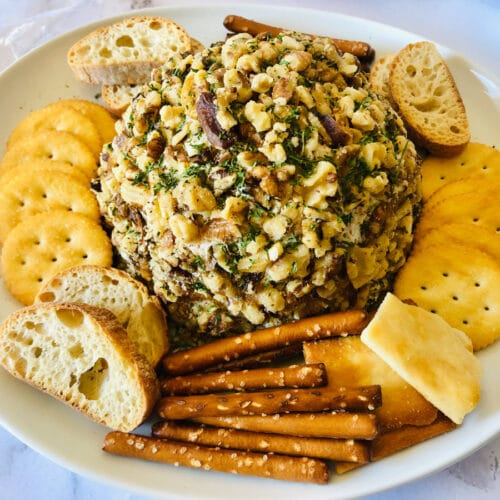 pineapple cheese ball with crackers, bread and pretzels around it